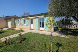 une maison avec des portes vertes dans une cour dans l'établissement JOLIE MAISON - CALME - JARDIN - GAILLAC, à Gaillac