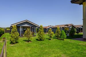 a house with a yard with trees in front of it at Nameliai Penkios gulbės in Šventoji