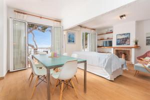 ein Wohnzimmer mit einem Tisch, Stühlen und einem Bett in der Unterkunft I Apartamento frente al mar en playa Tamariu in Tamariu