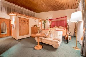 uma sala de estar com um sofá e uma cama em Hotel Vitalquelle Montafon em Schruns