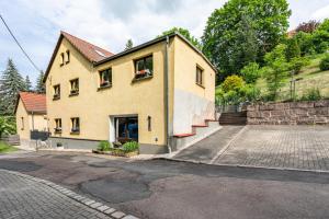 a house on a hill with a driveway at Ferienwohnung Am Mühlbach in Klipphausen