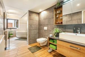 a bathroom with a sink and a toilet and a tub at Ferienwohnung Am Mühlbach in Klipphausen
