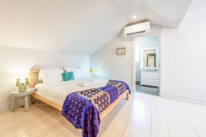 a white bedroom with a bed and a bathroom at GuestReady - Newly Renovated 3BR Apartment – Chiado in Lisbon