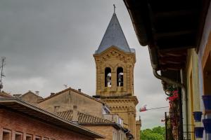 une grande tour d'horloge avec un clocher sur un bâtiment dans l'établissement Casa Ana Mari II by Clabao, à Pampelune