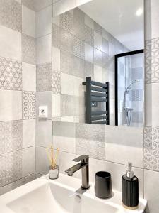 a bathroom with a sink and a mirror at Appartement cosy in La Mure +14 photos