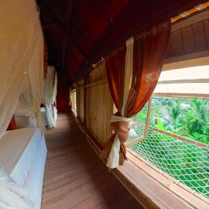 De Chicktoria Hostel في Pawenang: غرفة بها أسرة ونافذة على قطار