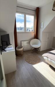 a bedroom with a bed and a desk and a chair at Appartement charmant et confortable en centre-ville in Condé-sur-Noireau