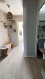 a living room with a wooden floor and a hallway at Appartement charmant et confortable en centre-ville in Condé-sur-Noireau +18 photos