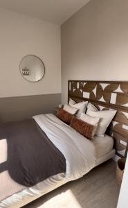 a bedroom with a large bed with a wooden headboard at Appartement charmant et confortable en centre-ville in Condé-sur-Noireau
