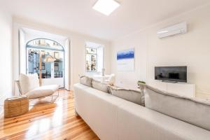 a white living room with a couch and a tv at GuestReady - Castle - Apt for 4 guests in Saldanha in Lisbon