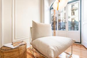 une chaise blanche dans une chambre avec fenêtre dans l'établissement GuestReady - Castle - Apt for 4 guests in Saldanha, à Lisbonne