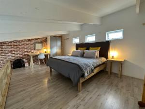 um quarto com uma cama e uma parede de tijolos em Modern apartments downtown em Plettenberg Bay