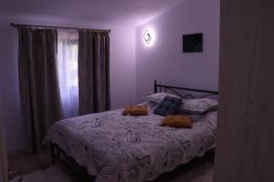 a bedroom with a bed with two pillows on it at Perfect view cottage with pool in Buhalniţa +45 photos