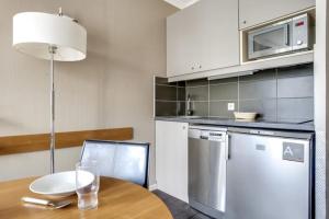 a kitchen with a table with a plate and a microwave at GuestReady - Studio near Porte de Versailles Metro in Issy-les-Moulineaux