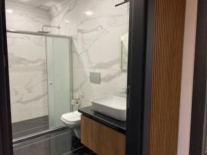 a bathroom with a sink and a toilet and a shower at Mayben Otel UZUNGÖL in Çaykara +65 photos