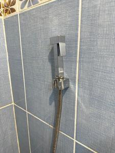 a shower with a hose in a blue tiled wall at Inceli Hotel in Uzungöl +55 photos