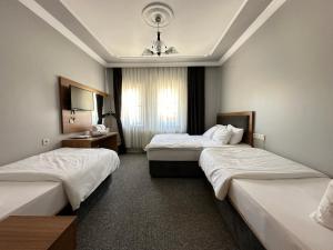 a hotel room with two beds and a chandelier at Inceli Hotel in Uzungöl