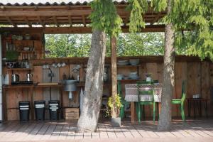 a patio with two trees and a table and chairs at Casa de campo glamping in Eželiškės