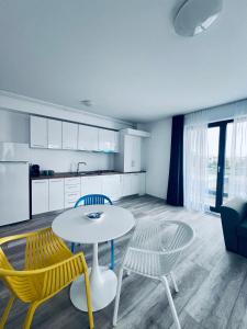 a living room with a table and chairs and a kitchen at Sea Panorama Apartments & Free Parking in Năvodari
