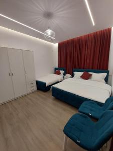 a bedroom with two beds and two chairs at GRAND HOTEL eae in Durrës