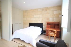 1 dormitorio con cama, escritorio y silla en GuestReady - Charming apartment in Place de la Comédie, en Burdeos