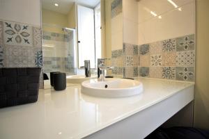 Baño blanco con lavabo y espejo en GuestReady - Charming apartment in Place de la Comédie, en Burdeos