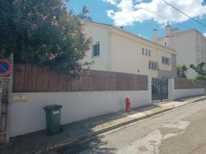 尼姆的住宿－Grand appartement, 2 chambres et jardin，一座白色的建筑,有栅栏和红色的消防栓