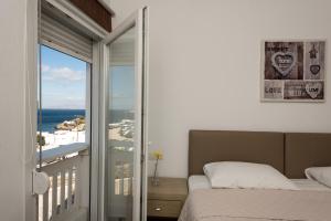 a bedroom with a bed and a view of the ocean at Olympia in Mikonos