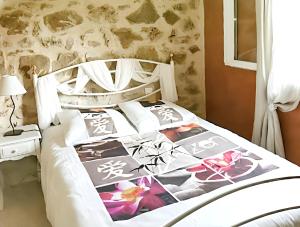 1 dormitorio con 1 cama con colcha de flores en Maison de 3 chambres avec piscine partagee jardin clos et wifi a Saint Victor la Coste, en Saint-Victor-la-Coste