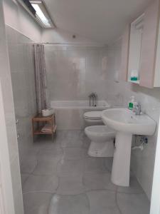 Consigliato monolocale في أنغري: حمام أبيض مع حوض ومرحاض