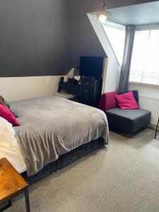 1 dormitorio con cama, escritorio y silla en Skyline Guesthouse en Newquay