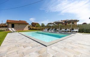 una piscina con sedie e una casa di 5 Bedroom Nice Home In Orentano a Orentano