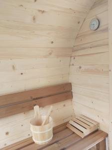 een houten sauna met een bank en een klok bij Domek pod Hajdówką in Jordanów