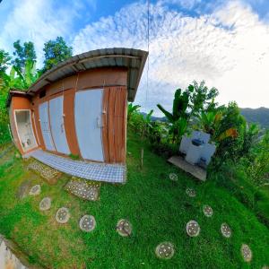 una pequeña casa en la hierba con algunas conchas en De Chicktoria Hostel, en Pawenang