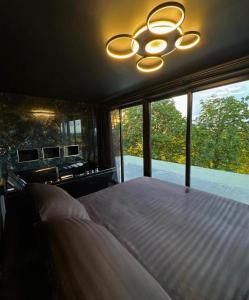 a bedroom with a large bed and a chandelier at Eco house 2 in Prestatyn
