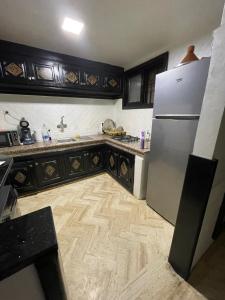 a kitchen with a refrigerator and a wooden floor at Riad marrakech boujloud in Marrakech +35 photos
