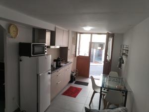 a small kitchen with a refrigerator and a table at Magistic Handi in Perpignan