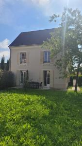 ein weißes Haus mit einem Tisch im Hof in der Unterkunft Disneyland Paris Modern Villa in Bailly-Romainvilliers