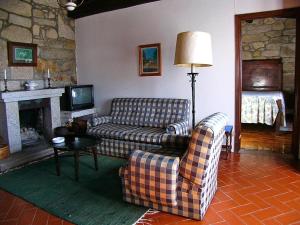 sala de estar con 2 sofás y chimenea en Quinta do Paco d'Anha en Viana do Castelo