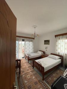 1 Schlafzimmer mit 2 Betten und einem Fenster in der Unterkunft Guest House Xhuljon in Berat
