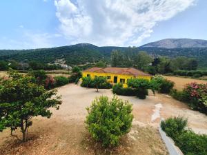 una casa amarilla en medio de un campo en Countryside Studios en Agia Efimia