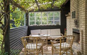 a patio with a table and two chairs and a couch at Nice Home In Sjællands Odde With Wifi in Yderby +8 photos