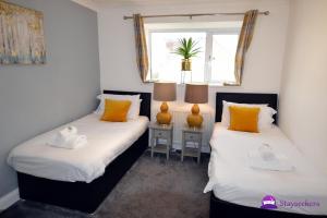 two twin beds in a room with a window at Oak Tree Boutique 2 bed Apartment - Stayseekers in Salisbury