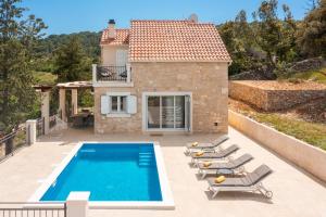 a villa with a swimming pool and lounge chairs at Emerald Eco Villa in Novo Selo
