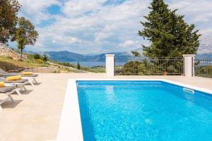 a pool with chairs and a view of the water at Emerald Eco Villa in Novo Selo