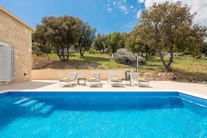 a swimming pool with lounge chairs and a house at Emerald Eco Villa in Novo Selo