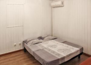 a bed in a room with white walls at Maison de 2 chambres a Saint Gilles les Bains a 500 m de la plage avec terrasse amenagee et wifi in Saint-Gilles-les-Bains
