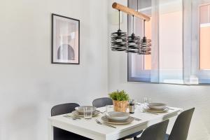 a white dining room table with chairs and a chandelier at Neubau Luxus Penthouse - Netflix - BBQ in Mannheim