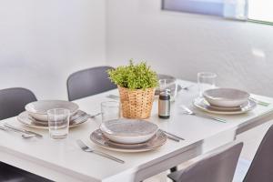 a table with plates and a potted plant on it at Neubau Luxus Penthouse - Netflix - BBQ in Mannheim
