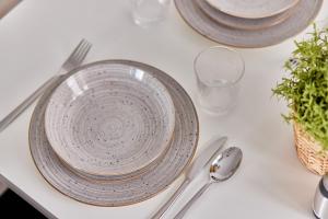 a white table with plates and silverware on it at Neubau Luxus Penthouse - Netflix - BBQ in Mannheim